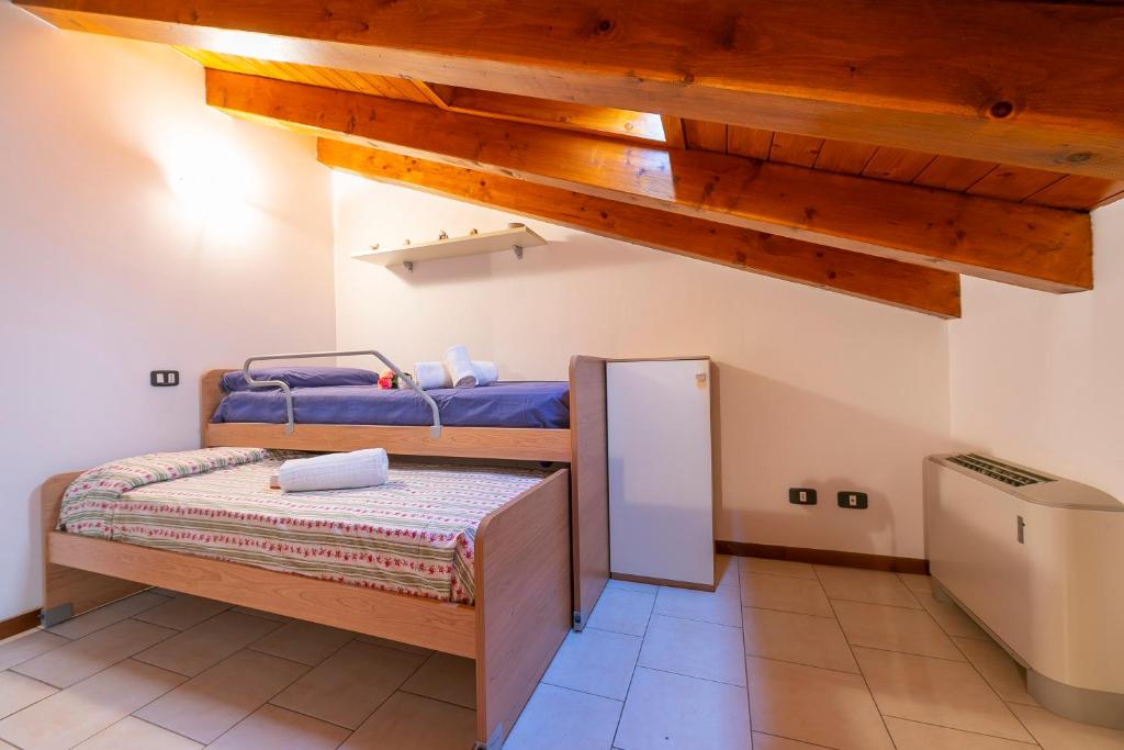 sypialnia z 2 łóżkami piętrowymi i lodówką w obiekcie VistaLago Green Residence 100m From Lake - Happy Rentals w mieście Desenzano del Garda