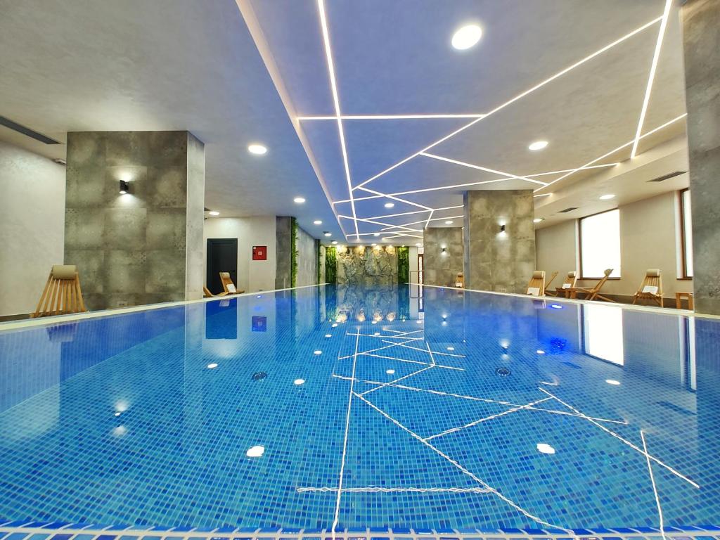 a large swimming pool with a blue tile floor at Velika Recepcija CC Magnet in Zlatibor