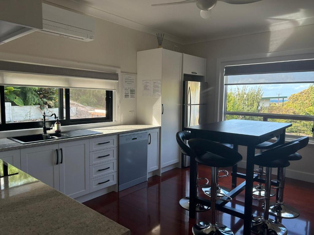 a kitchen with a table and two bar stools at Happy Valley Rest in Port Lincoln