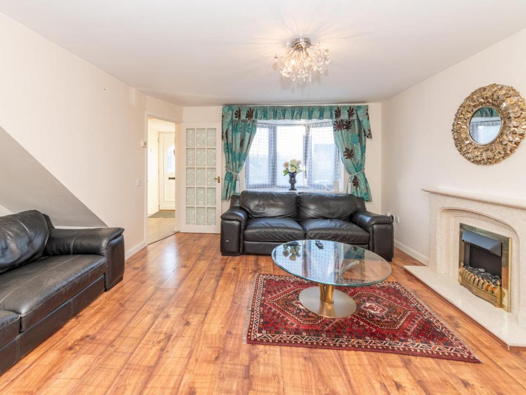 a living room with a leather couch and a glass table at Spacious Home with Modern Amenities Near IKEA Pass the Keys in Reading