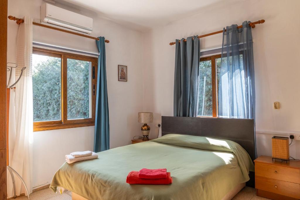 a bedroom with a large bed with blue curtains at Spiti Damianos Villa Beachfront in Pomos