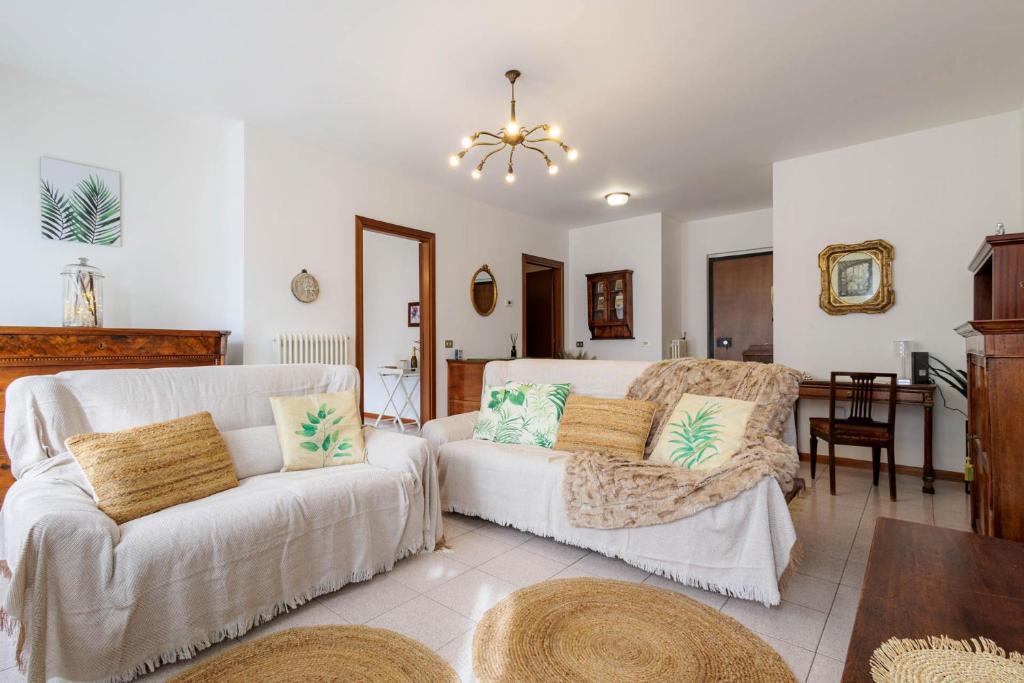 een woonkamer met een bank en een stoel bij Revo Apartments - Quadrifoglio in Sondrio
