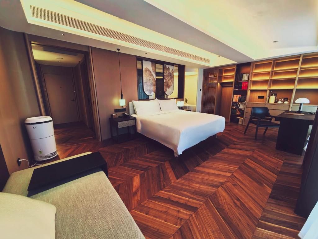 um quarto com uma grande cama branca e uma secretária em The Purple Horse em Pequim