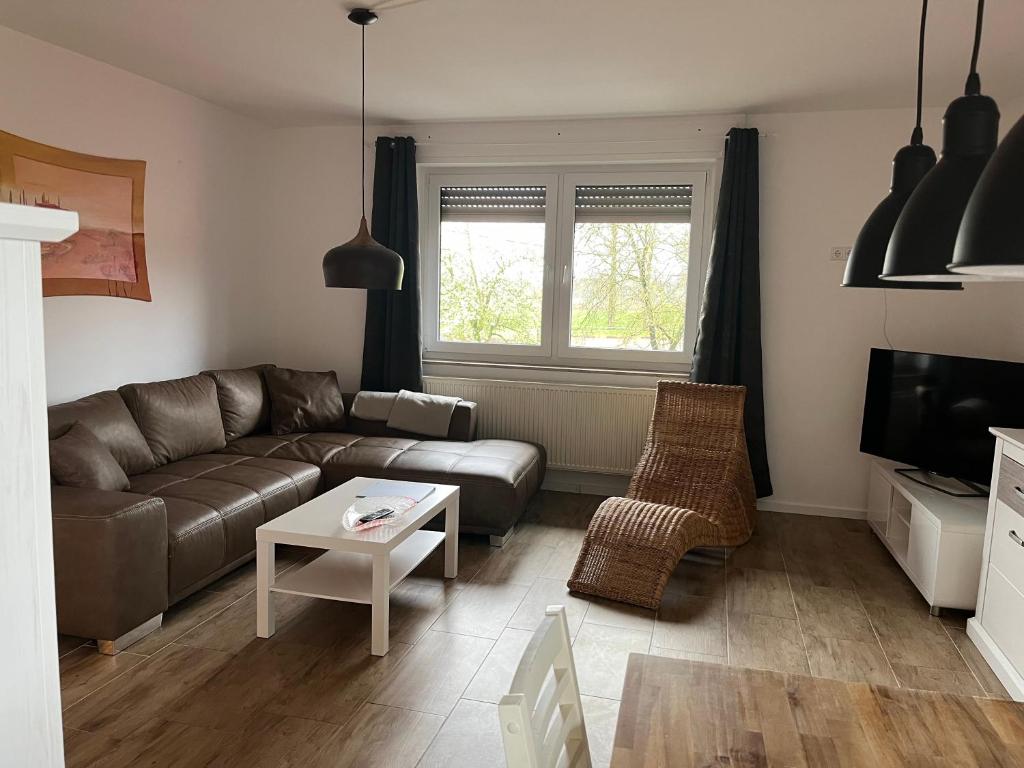 ein Wohnzimmer mit einem Sofa und einem Tisch in der Unterkunft Wunderschöne Ferienwohnung mit Balkon auf dem Bauernhof in Greven
