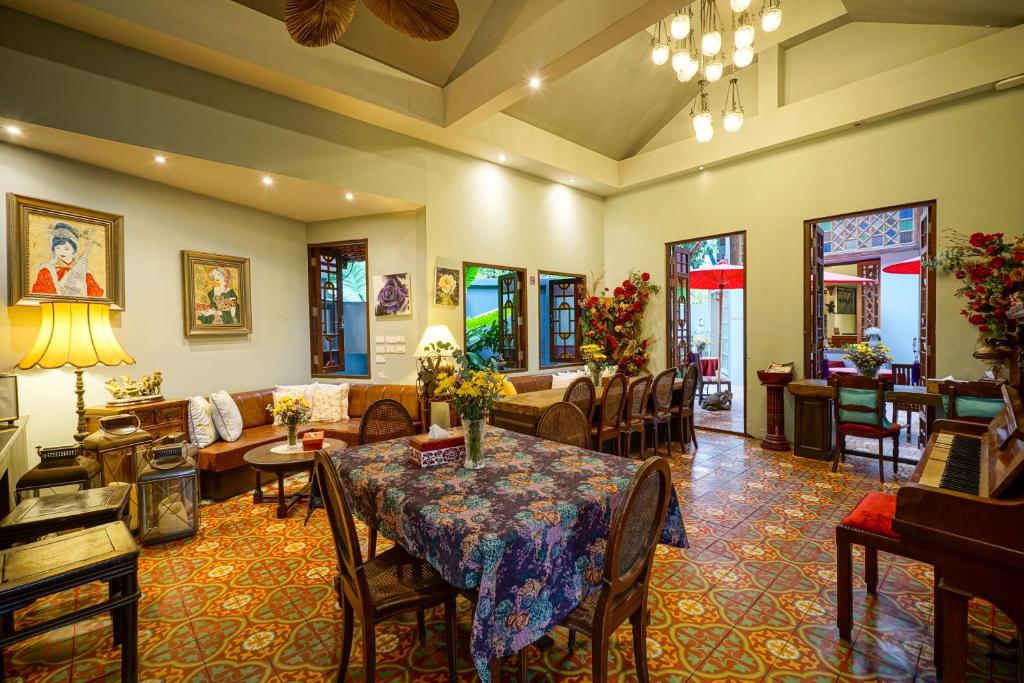 A richly decorated lounge and dining-style sitting area combines sofas, tables, artwork and patterned flooring.