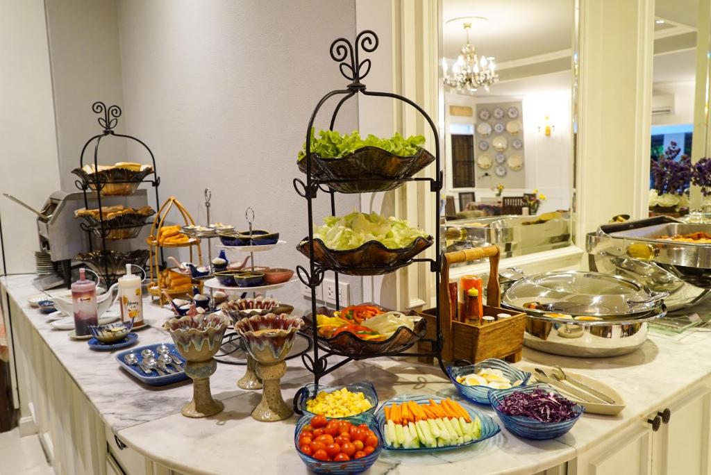 A buffet counter with salads, vegetables, sauces, desserts, and covered dishes.