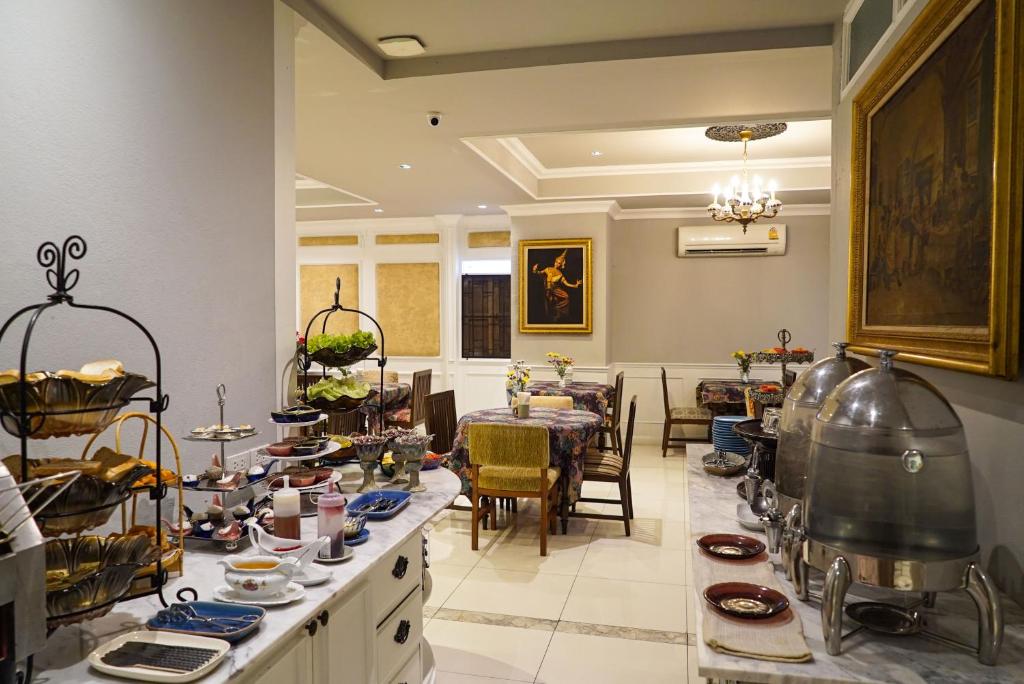 A breakfast buffet room offers tea service, covered dishes, pastries and seated tables in a bright dining space.