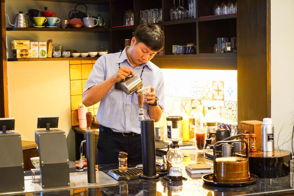 A staff member prepares a drink at a well-equipped hotel beverage counter.