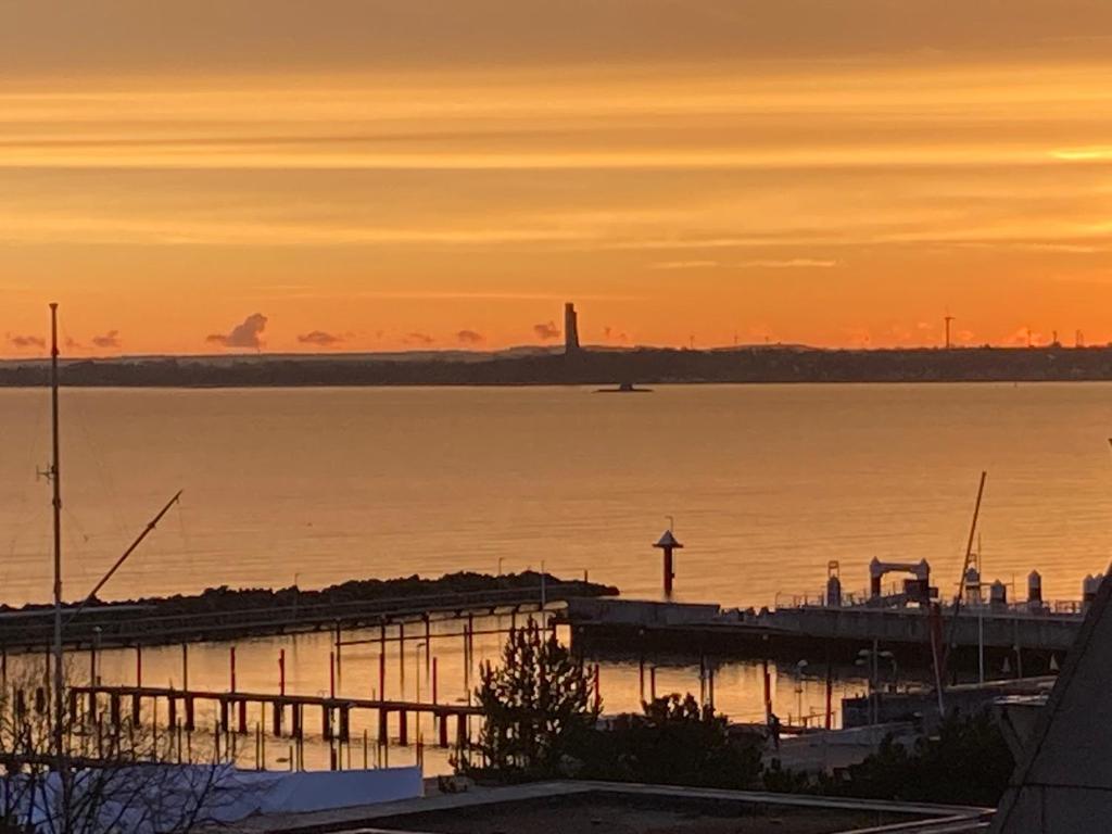 a sunset over a body of water with a pier at Ferienwohnung Schlosser in Kiel