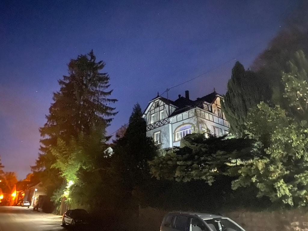 um grande edifício à noite com um carro estacionado na frente em LA VILLA DES OISEAUX - La Petite Pierre em La Petite-Pierre