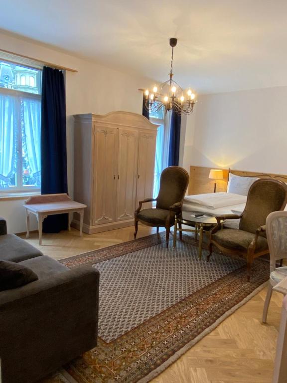 ein Wohnzimmer mit einem Sofa, Stühlen und einem Tisch in der Unterkunft Carlton-Europe Vintage Adults Hotel in Interlaken