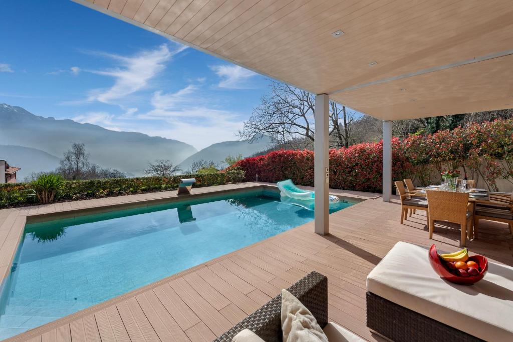 a swimming pool in a backyard with a table and chairs at Villa Dolce Vita With Private Pool - Happy Rentals in Lugano