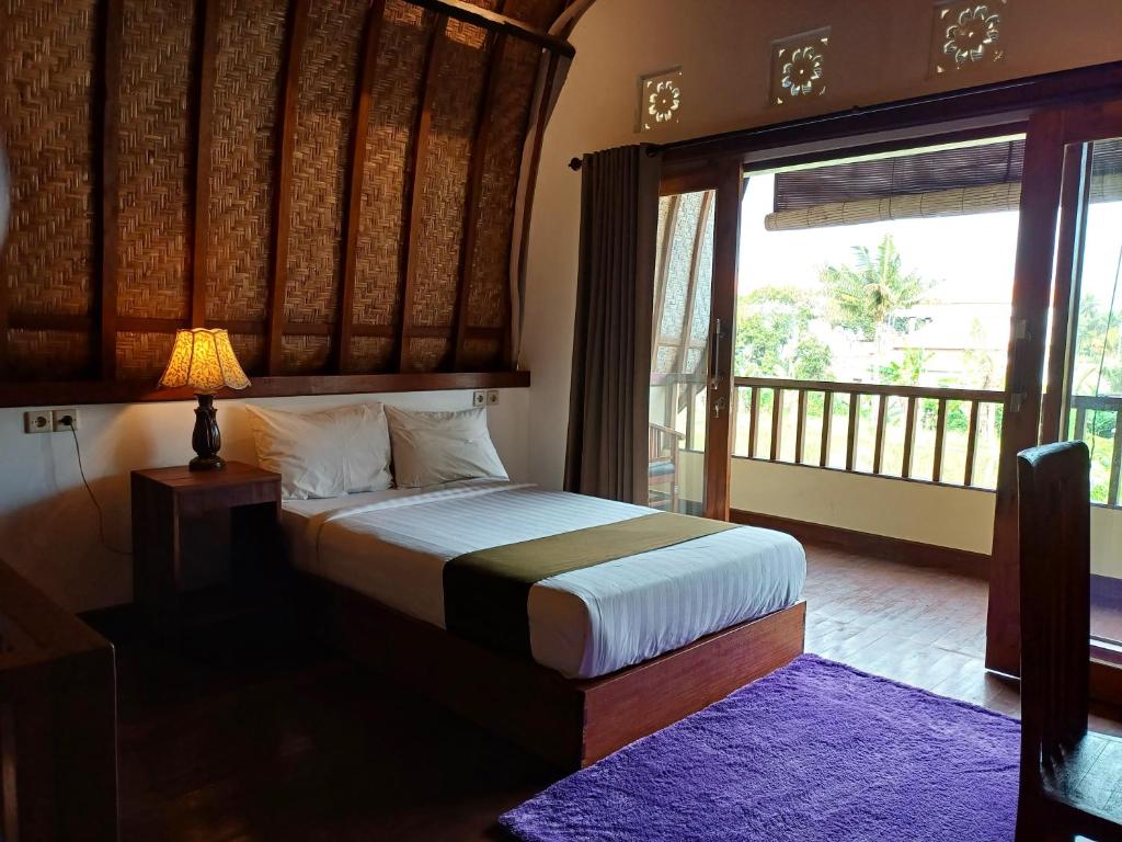 - une chambre avec un lit et une grande fenêtre dans l'établissement Relaxing 2 Bedroom Villa With Private Pool, à Ubud