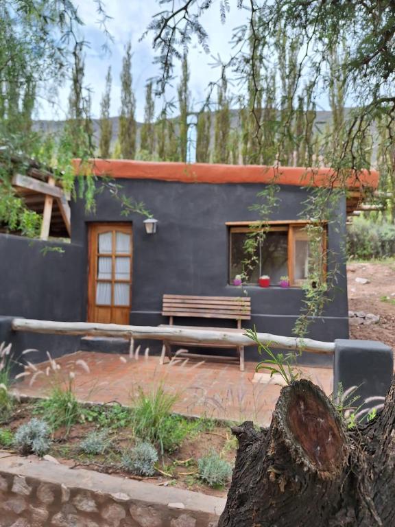 a small house with a bench in front of it at El Sueñero in Tilcara