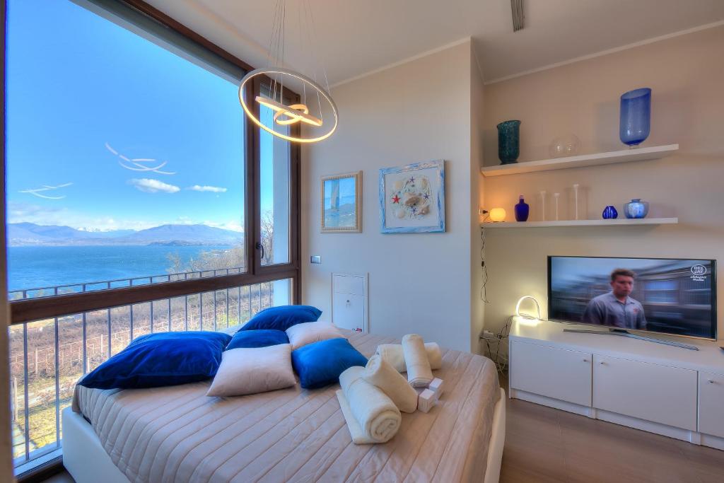 1 dormitorio con 1 cama grande y ventana grande en Suite on The Lake, en Meina