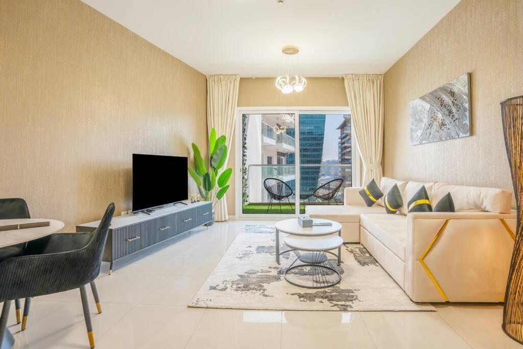 a living room with a couch and a tv at Specious pool view One Bed room in Dubai