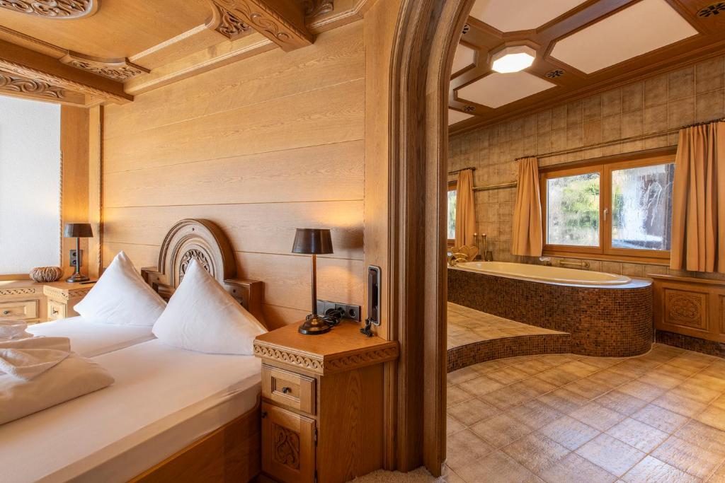a bedroom with a bed and a tub in a room at Chalet Waldhaus Rappakopf in Schruns