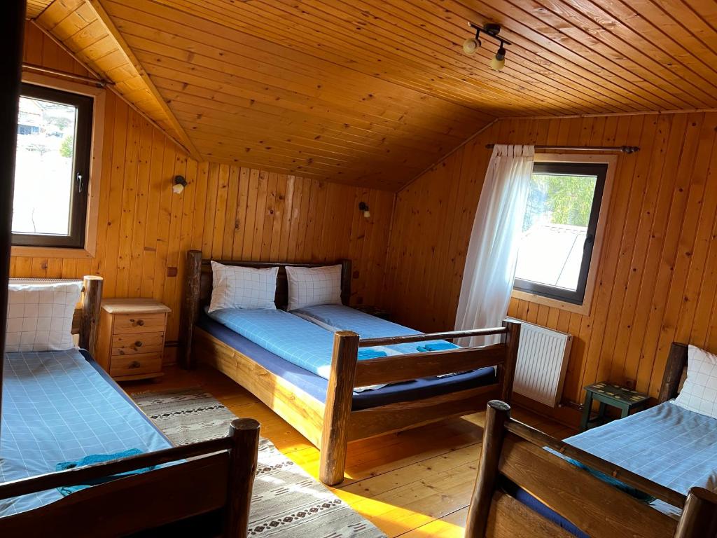 una camera con 2 letti in una cabina di legno di Cabana Craiu Garana a Gărâna