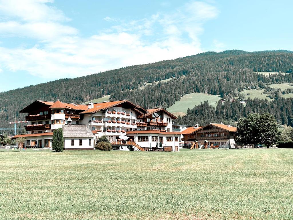 a large building in the middle of a field at Hotel Das Urbisgut in Altenmarkt im Pongau