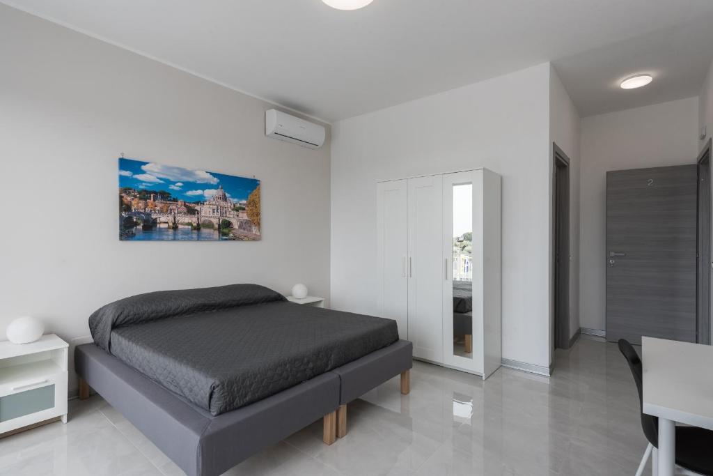 um quarto com uma cama, uma mesa e uma secretária em Travelershome Ciampino Airport GuestHouse em Ciampino