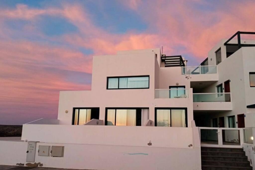 a white building with a sunset in the background at casa Emilia Cotillo Mar in Cotillo