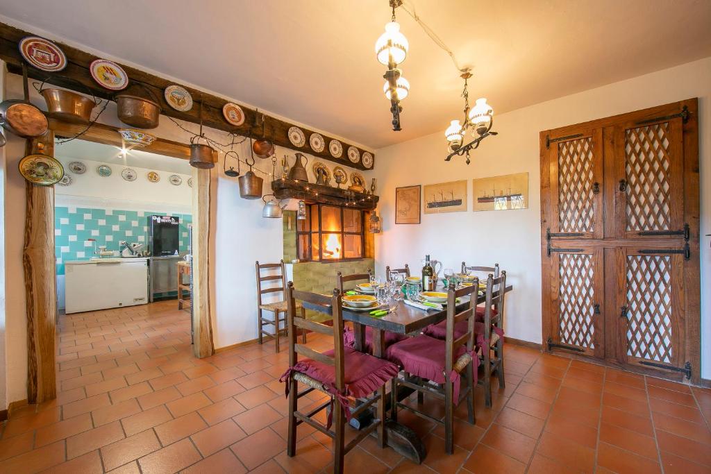 kuchnia i jadalnia ze stołem i krzesłami w obiekcie Charming Villa I Tre Archi - Happy Rentals w mieście Pisano