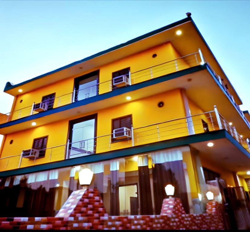 ein gelbes Gebäude mit einem Balkon an der Seite in der Unterkunft Hotel Pragati Palace in Mathura