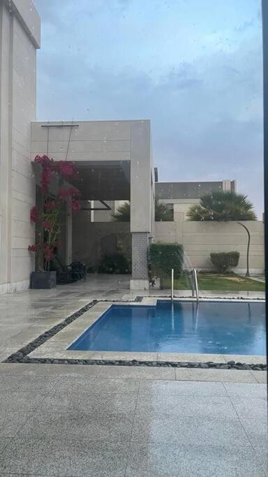 uma piscina em frente a um edifício em شاليه فيلا غرفتين نوم em ‘Anqāʼ