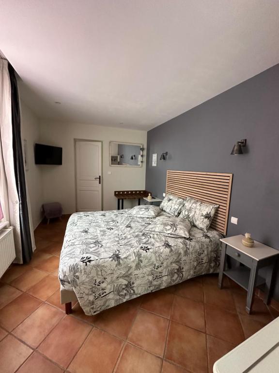 Chez Camille في إيبيرني: غرفة نوم بسرير وطاولة