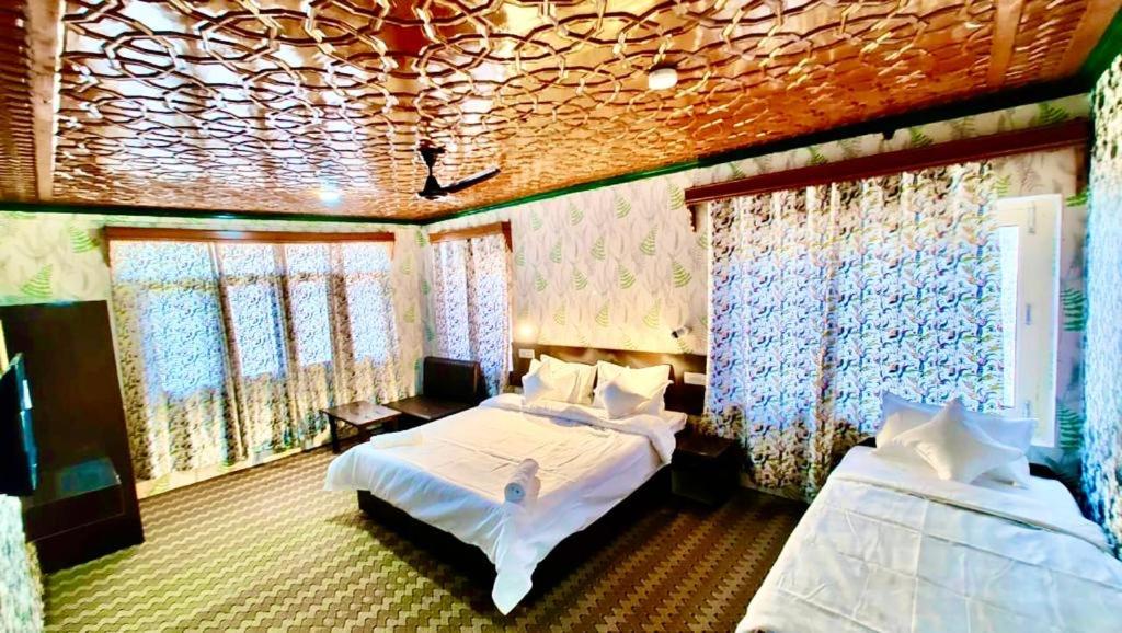 1 dormitorio con 2 camas en una habitación con ventanas en Diamond cottage, en Srinagar