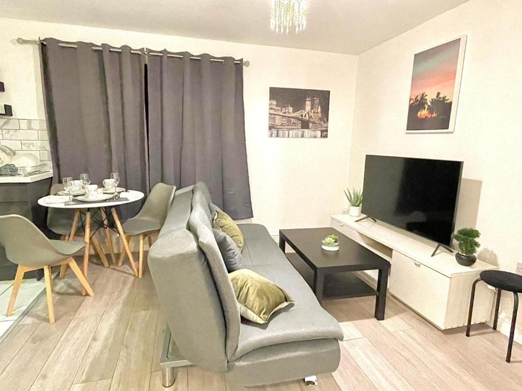 uma sala de estar com um sofá, uma televisão e uma mesa em Lovely Modern 3 Bedroom House Doncaster, Family Contractor Friendly, Sleeps 5 em Carcroft