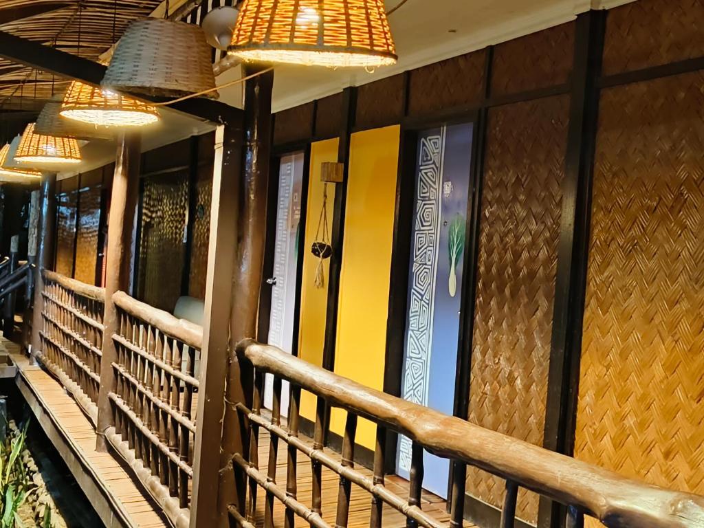 budynek z żółtymi drzwiami i żyrandolami w obiekcie Lokal Hut Bed and Breakfast w mieście Puerto Princesa