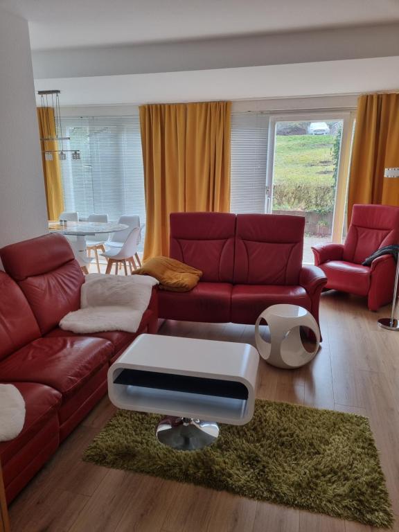 a living room with a red couch and a table at Ferienwohnung im Villenviertel Ilmenau in Ilmenau