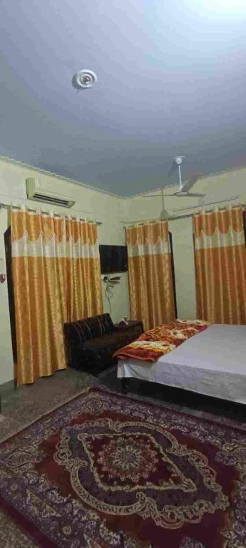 een slaapkamer met 2 bedden en een tapijt bij Ratan home stay in Faizābād