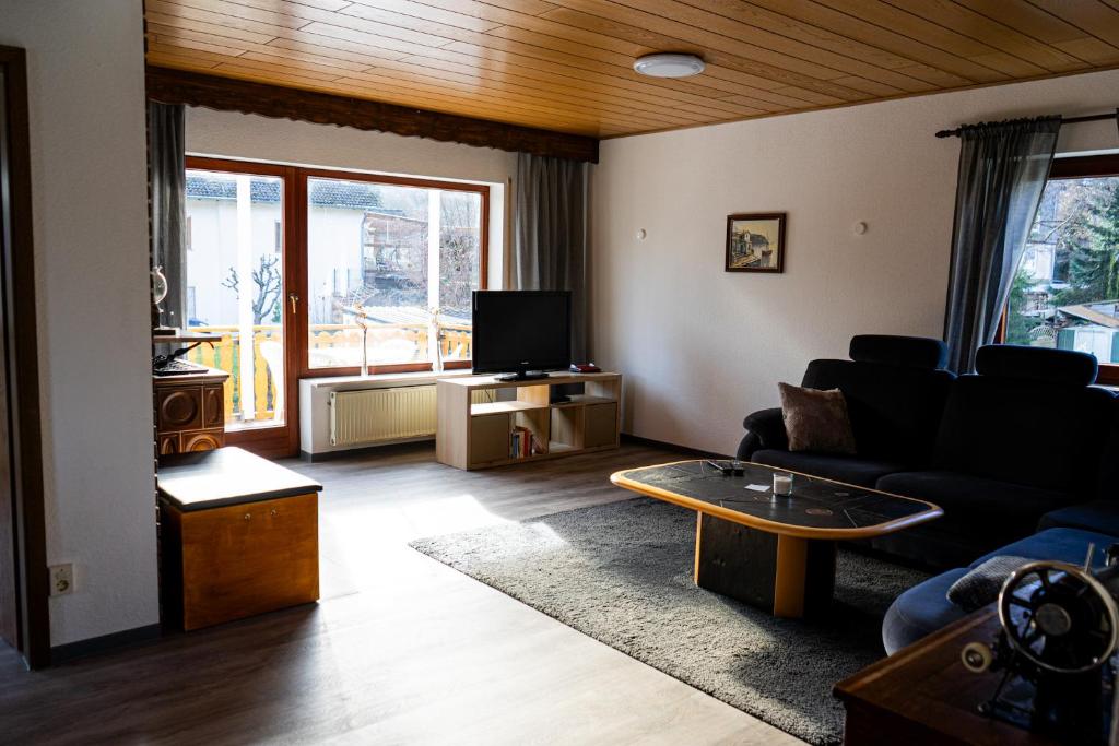 a living room with a couch and a tv at Ferienwohnung Am Rhaunelbach in Rhaunen