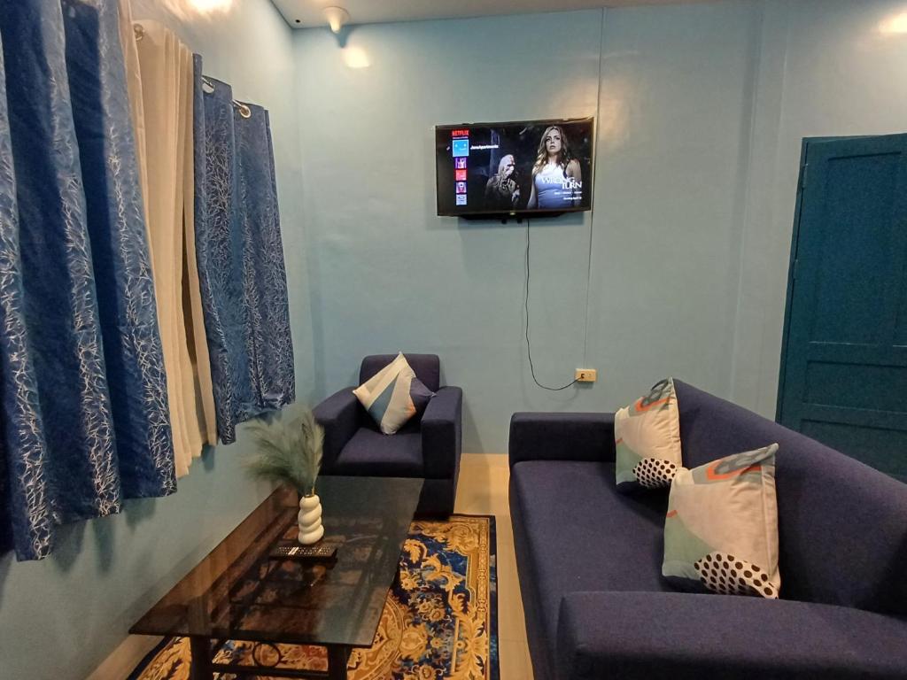- un salon avec deux canapés et une télévision murale dans l'établissement 2br Hilltop Haven w/ Wi-Fi, à Davao