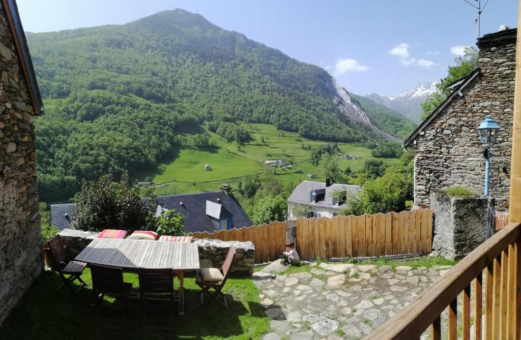d'un balcon avec une table, des chaises et des montagnes. dans l'établissement Grande maison de village, rénovation écologique, à Viey