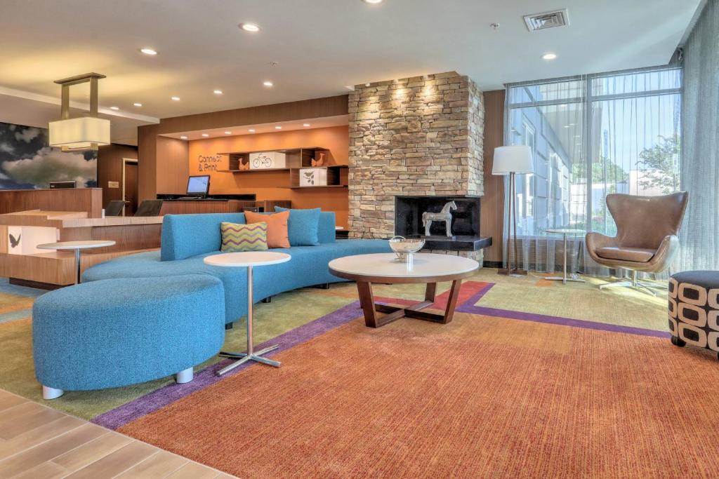 salon z niebieską kanapą i kominkiem w obiekcie Fairfield Inn & Suites by Marriott Greenville w mieście Greenville