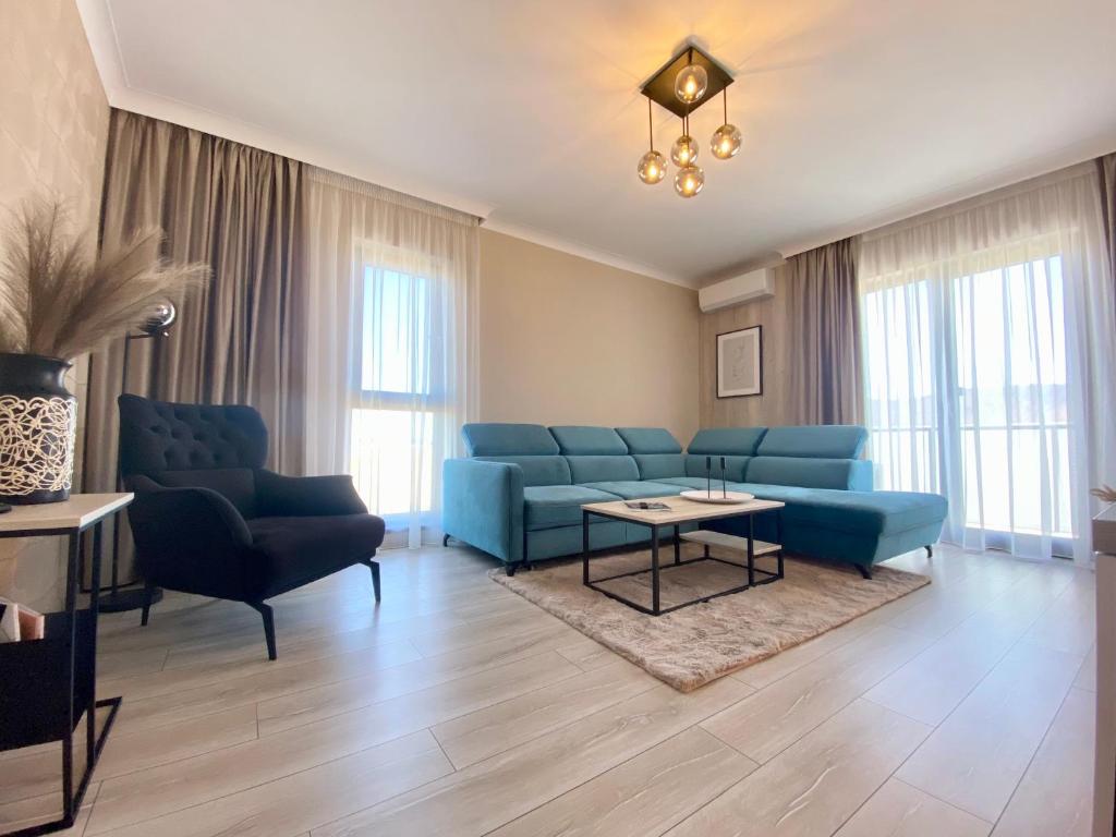 ein Wohnzimmer mit blauen Sofas und einem Tisch in der Unterkunft Alessia Apartment in Cristian