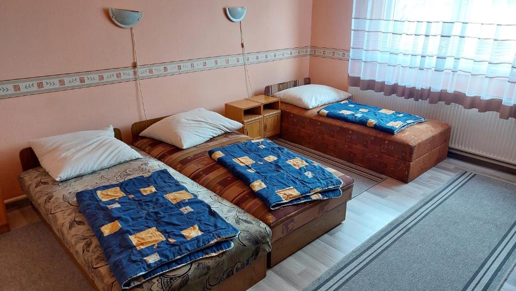 a room with two beds and a couch in it at Napsugár Panzió in Vác
