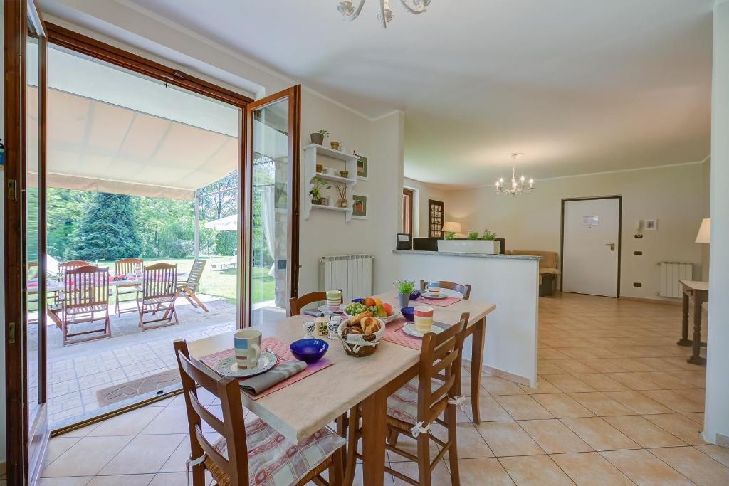 kuchnia i jadalnia ze stołem i krzesłami w obiekcie Villa La Dolce Vita - Happy Rentals w mieście Leggiuno