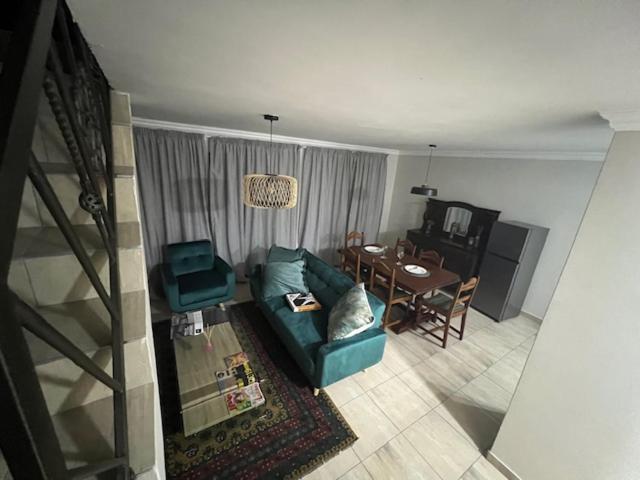 ein Wohnzimmer mit einem blauen Sofa und einem Tisch in der Unterkunft Tintswalo Elegant Apartments in Giyani