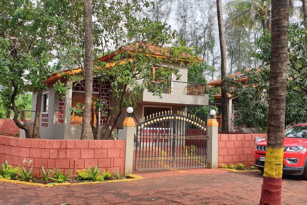 une maison avec un portail et une voiture garée devant dans l'établissement Dev Villa, à Dapoli