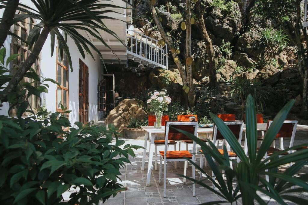a patio with a table and chairs and plants at AROMA HOUSE - Private entire house on Cat Ba island in Cat Ba
