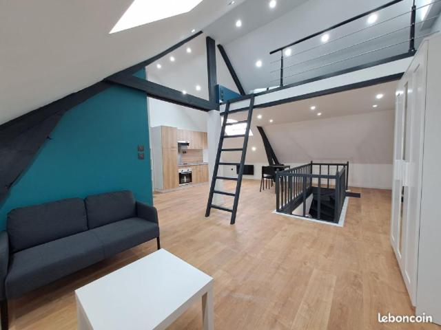 uma sala de estar com um sofá e uma escada em espiral em *Le Cristal Doré*Wifi*Parking em Lens
