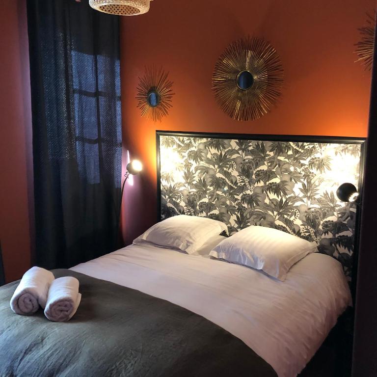 une chambre avec un grand lit avec deux serviettes dessus dans l'établissement Appart's Casa Mina, à Saint-Malo