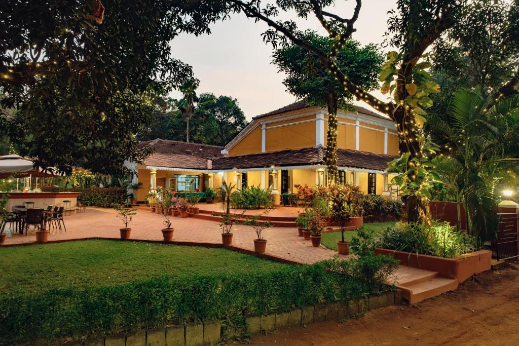 une maison avec un jardin en face dans l'établissement Granpa's Inn Hotel Bougainvillea, à Anjuna