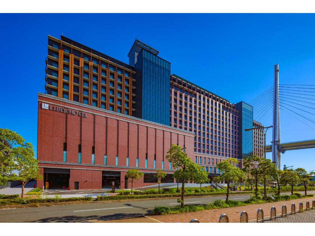 a large red brick building with tall buildings at LIBER HOTEL Osaka in Osaka