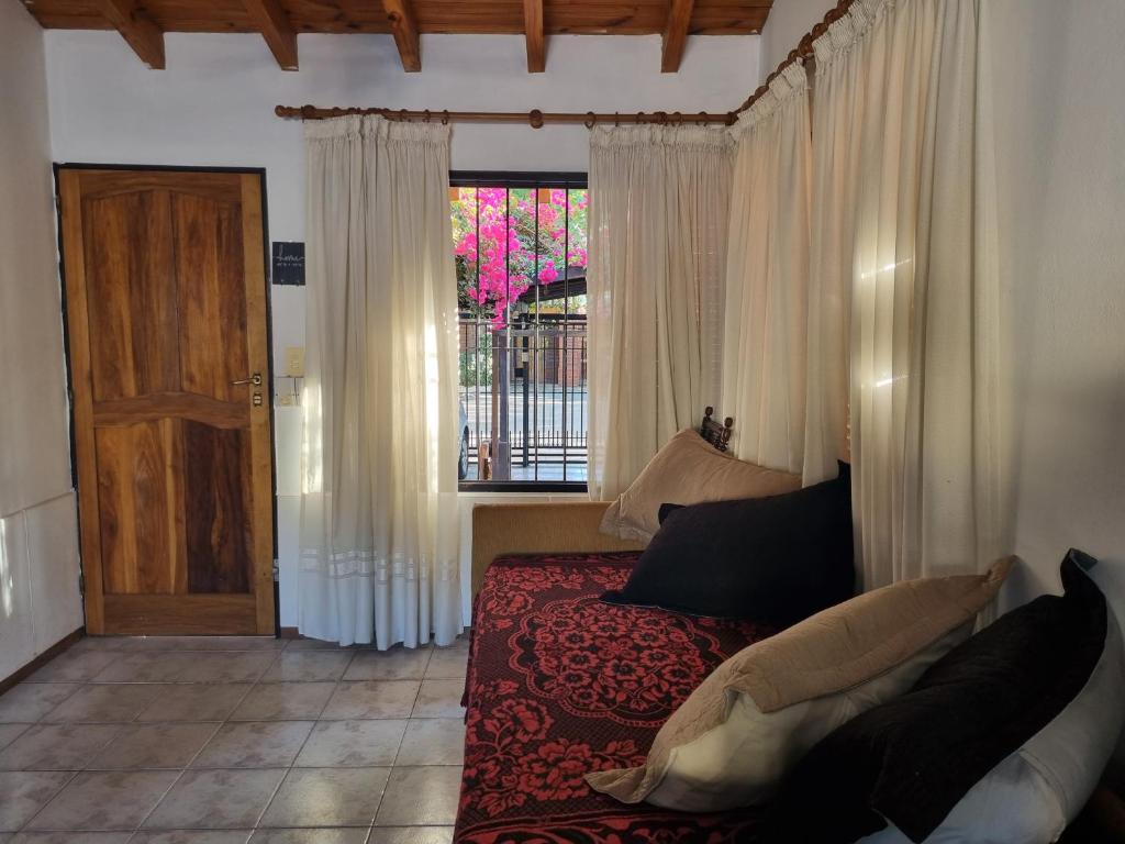 um quarto com uma cama, uma janela e uma porta em La casa de Chiqui em Mendoza