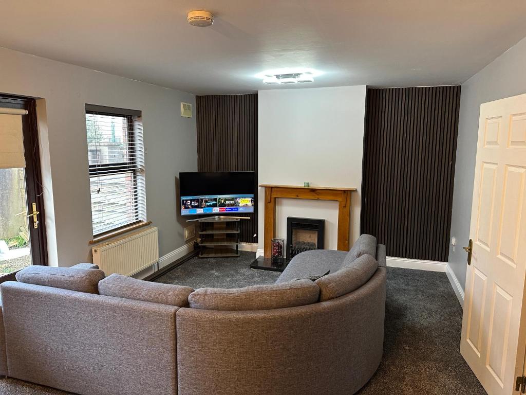 uma sala de estar com um sofá e uma televisão em Cosy Room em Shannon